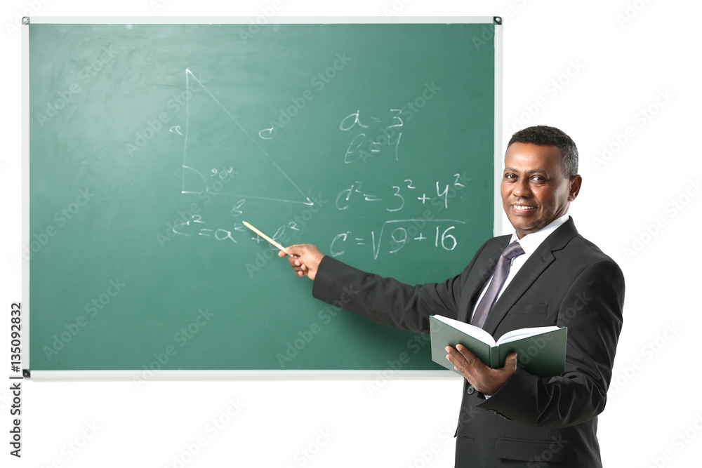 Indian teacher explaining math formulas written on blackboard Indian teacher explaining math formulas written on blackboard