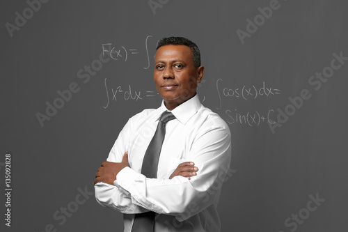 Photo Confident Indian teacher standing near blackboard