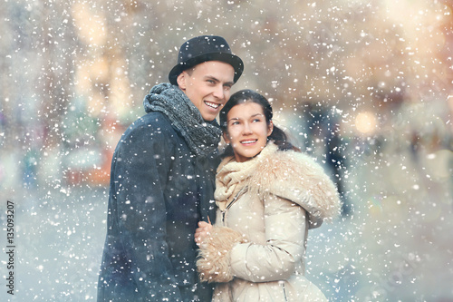 Young couple in snowfall ou...