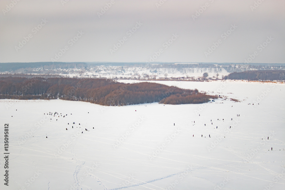 Lot of people fishing on the ice in winter