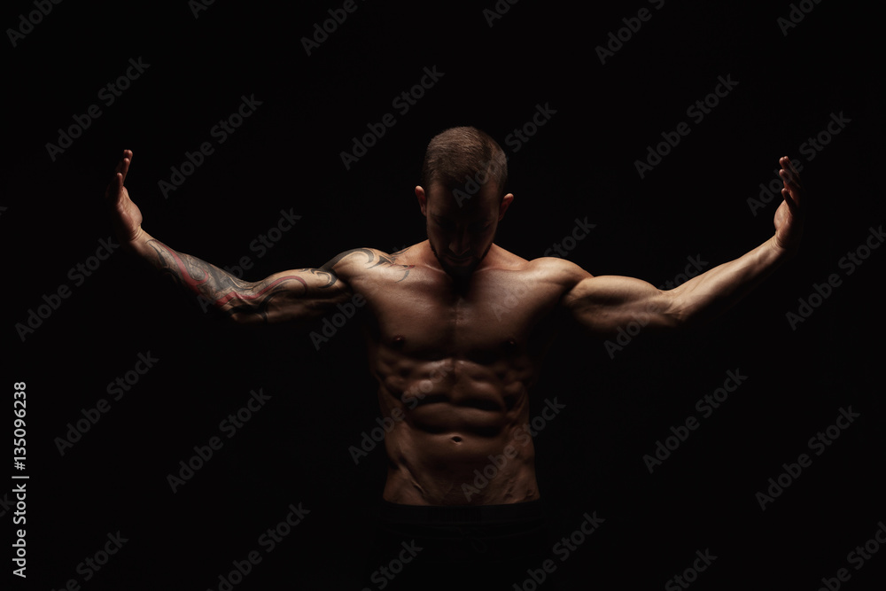 Strong athletic man showes naked muscular body Strong athletic man showes naked muscular body