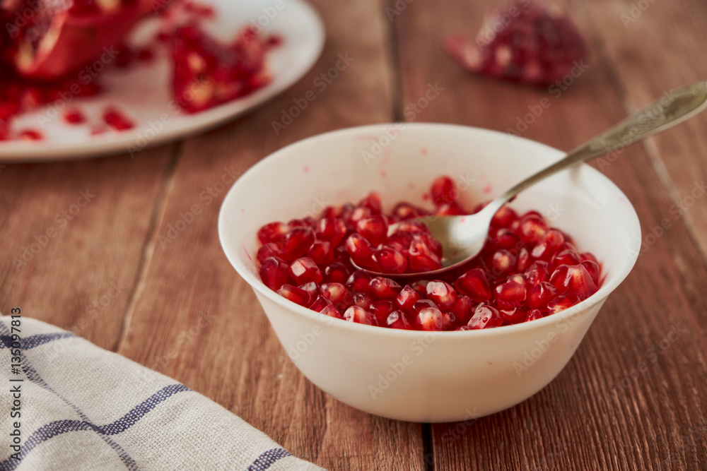 Delicious ripe pomegranates on a wooden table Delicious ripe pomegranates on a wooden table