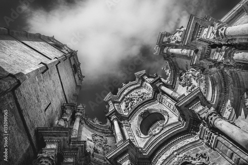 Dramatic scene with clouds and facade of  Metropolitan Cathedral–Basilica of the Assumption of Our Lady of Valencia, Spain. Black and white image. 