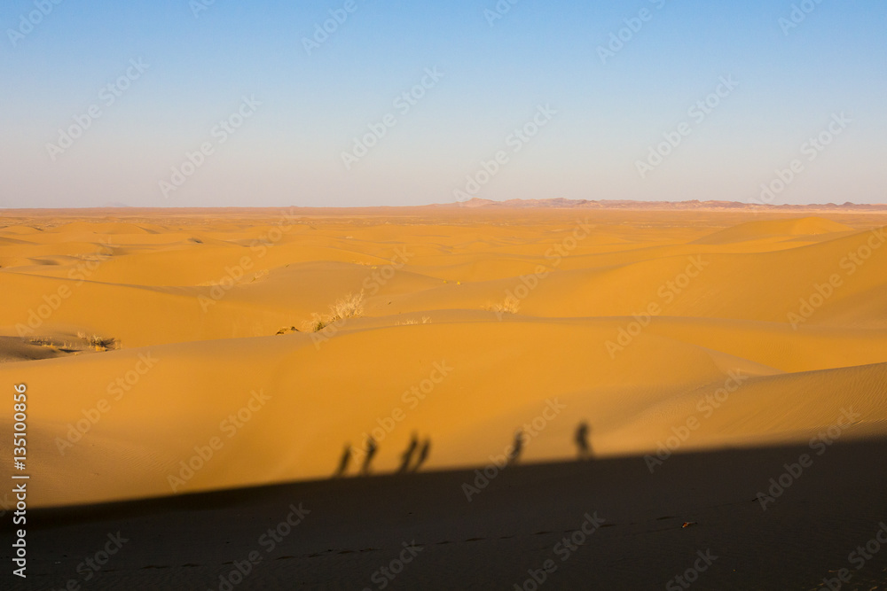 Shadows of people walking on Sand dunes in the Maranjab desert, near Kashan, Iran. Shadows of people walking on Sand dunes in the Maranjab desert, near Kashan, Iran.