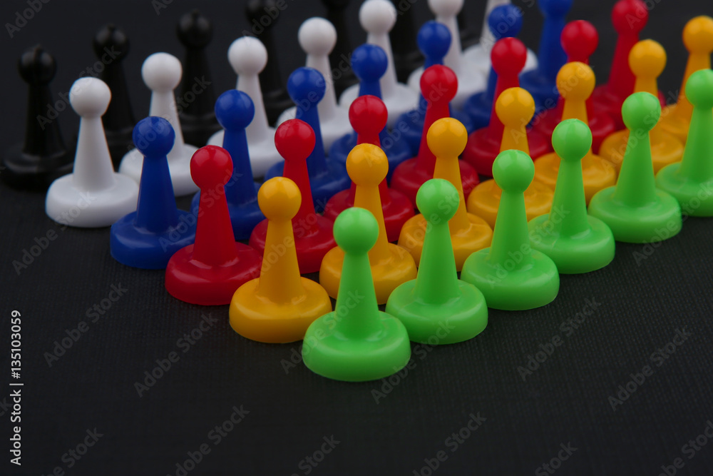 Colorful play figures. Board game pieces on black background.