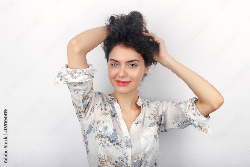Naklejka premium Beauty portrait of young adorable fresh looking brunette woman playing with her long brown healthy curly braided hair. Emotion and facial expression concept.