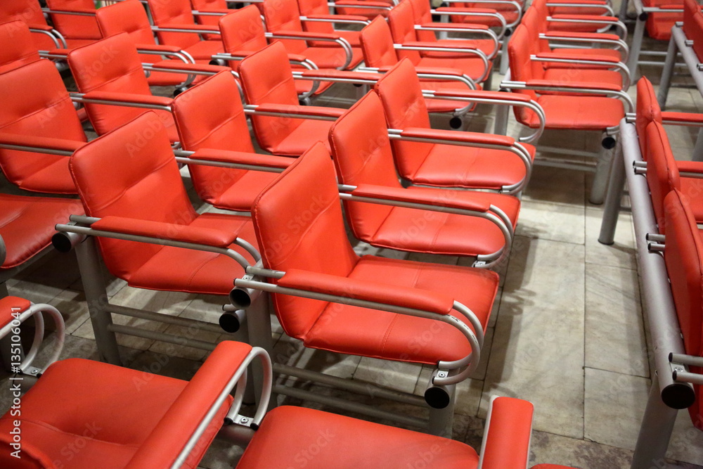 Fototapeta premium Armchairs with metal frame and red leather upholstery in a row
