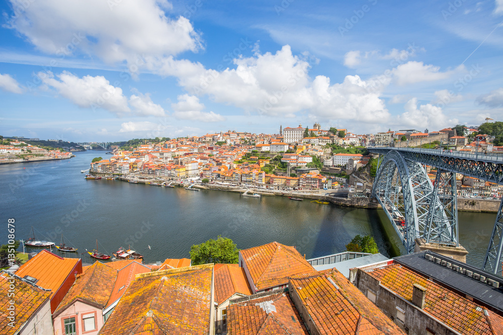 View of the historic city of Porto, Portugal with the Dom Luiz bridge. across the Douro river and the traditional rabelo boats