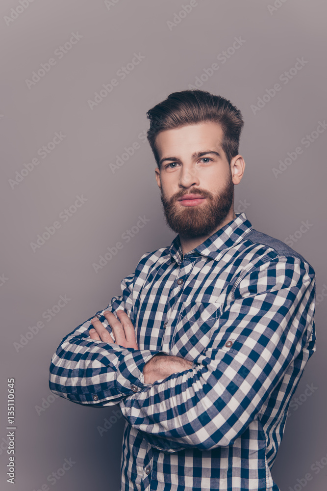 Fototapeta premium Portrait of serious confident young man with crossed hands