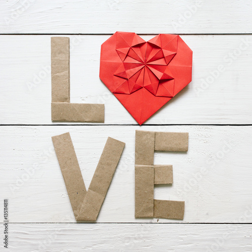 Red origami heart, craft paper folded letters Love inscription on white painted rustic rural barn wood background. Nice Valentines day holiday square greeting card, postcard.