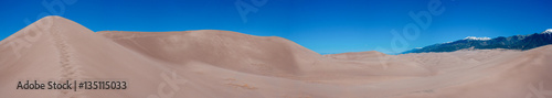 A panoramic photo of the sand dunes and mountains at Great Sand Dunes National Park in Colorado.