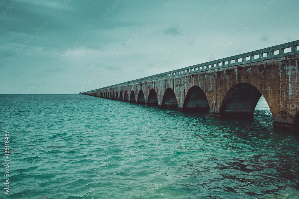 Colorful panoramic landscape of a beautiful  sunset at Bahia Honda state park in Florida and the old historic landmark, the Flagler railway bridge that used to connect Miami and Key West.