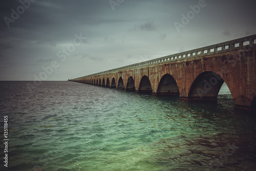 Colorful panoramic landscape of a beautiful  sunset at Bahia Honda state park in Florida and the old historic landmark, the Flagler railway bridge that used to connect Miami and Key West. © Julia