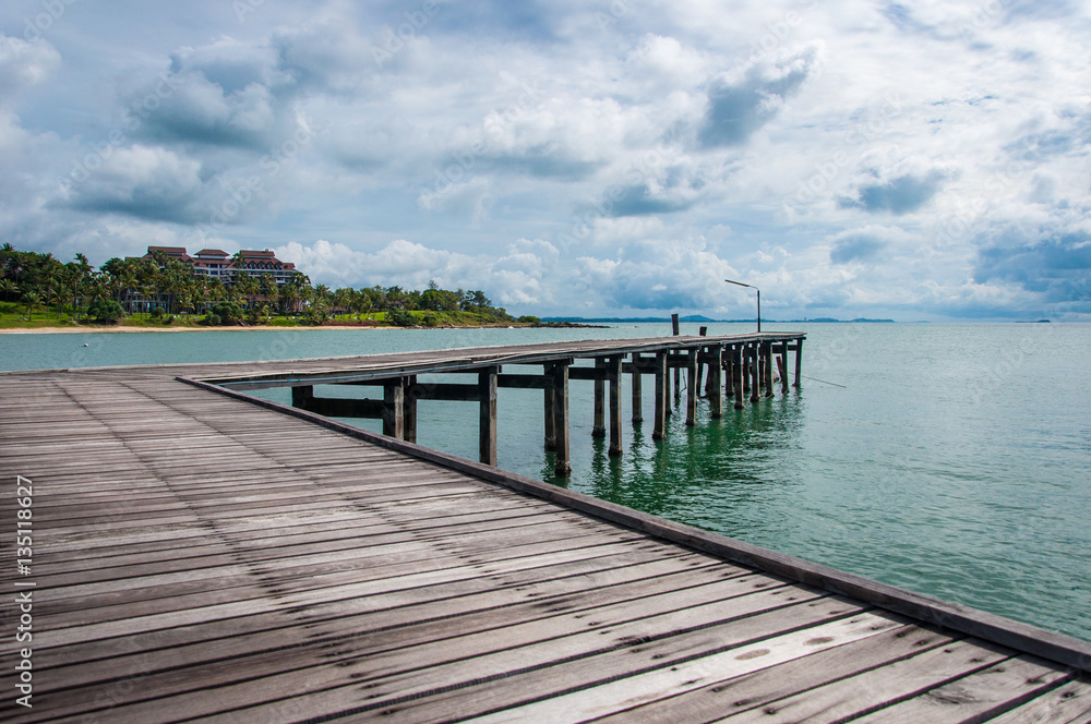 Beautiful Wooden Jetty with Dramatic Sky and Green Island Backg Beautiful Wooden Jetty with Dramatic Sky and Green Island Backg