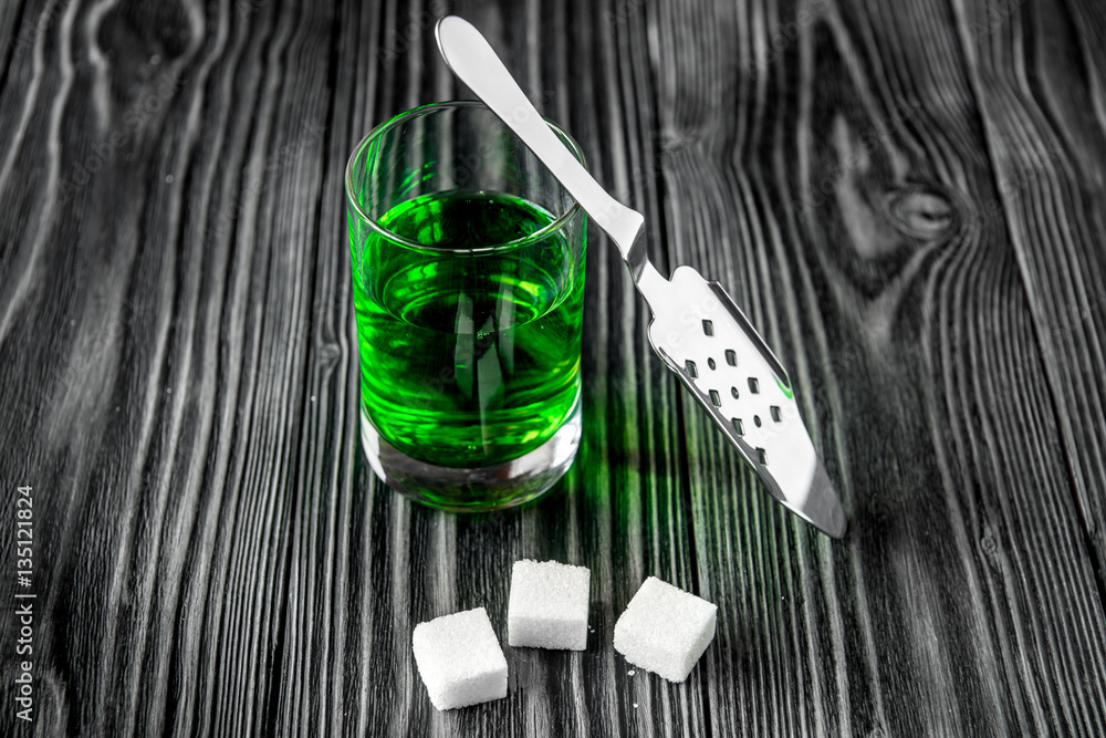 absinthe with sugar cubes and spoon on wooden background absinthe with sugar cubes and spoon on wooden background