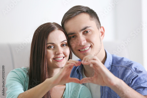 Happy couple making heart b...