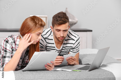 Young couple calculating ta...