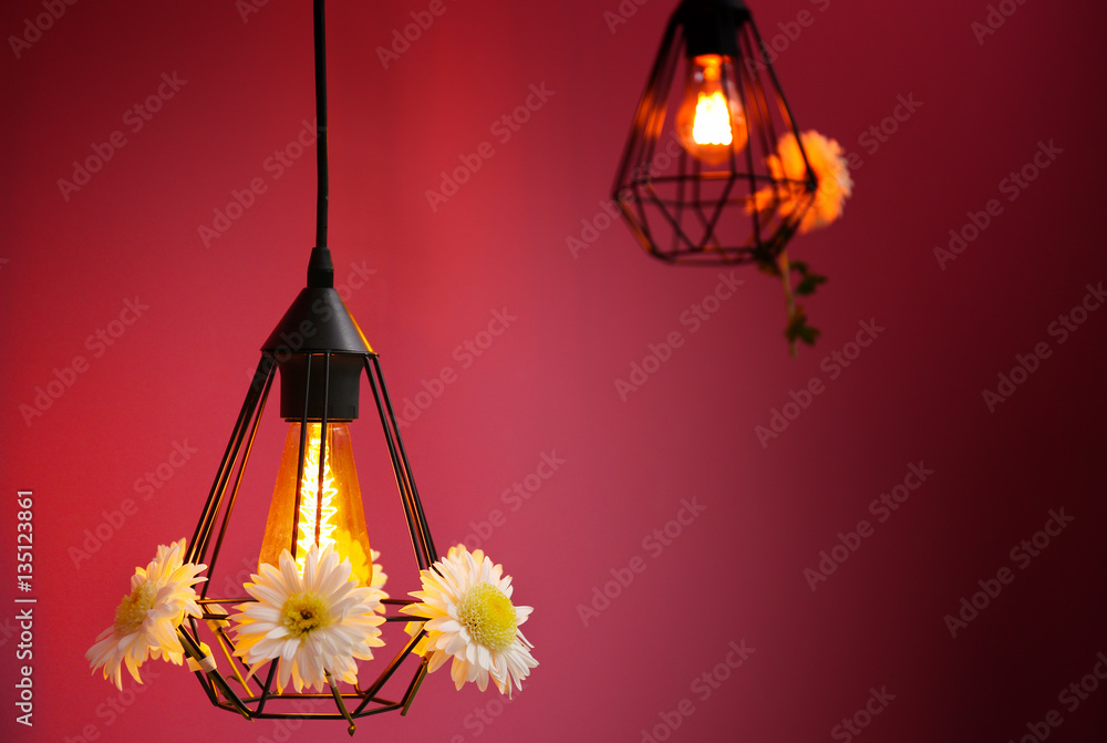 Lamps decorated with flower garland on purple background
