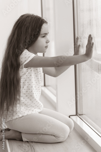Little sad girl sitting on ...