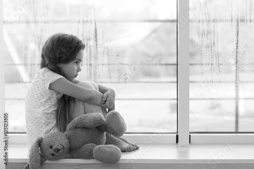 Little sad girl sitting on ...