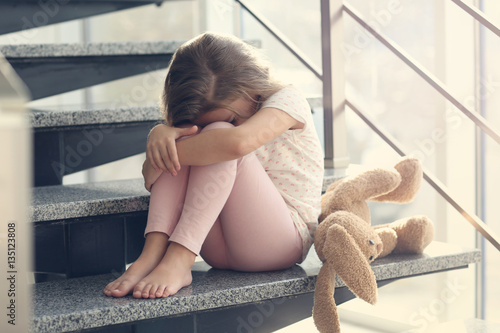 Sad little girl sitting on ...