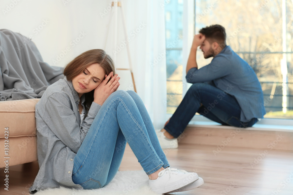 Fototapeta premium Young sad couple after quarrel at home