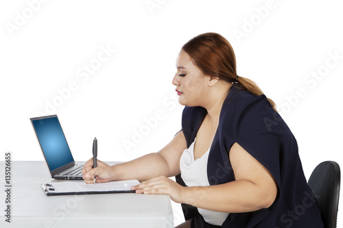 Businesswoman writes on paperwork