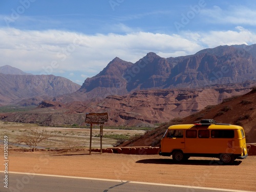 Yellow Kombi parked in front of red dry valley on the way to Cafayate in Nth Argentina. 