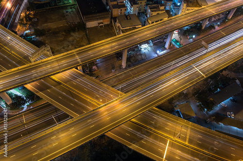 Top view of massive expressway at night with light of cars, tran