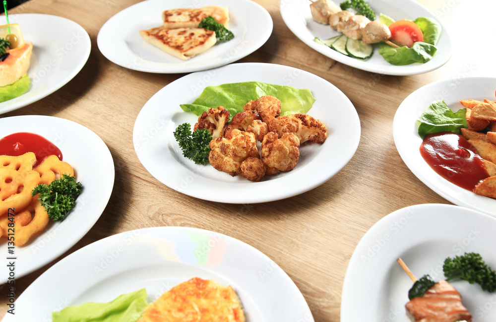 many delicious dishes on a table in restaurant many delicious dishes on a table in restaurant