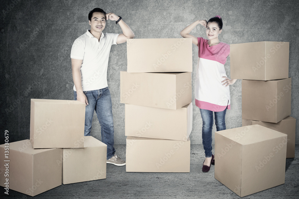 Young man and woman standing with box Young man and woman standing with box