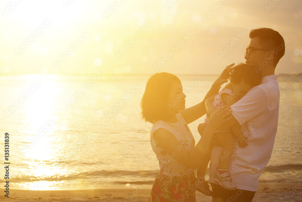 Family enjoying holiday vacation on seaside in sunset