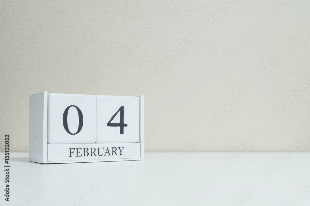 Closeup white wooden calendar with black 4 february word on blurred white wood desk and cream color wallpaper in room textured background with copy space in selective focus at the calendar Closeup white wooden calendar with black 4 february word on blurred white wood desk and cream color wallpaper in room textured background with copy space in selective focus at the calendar