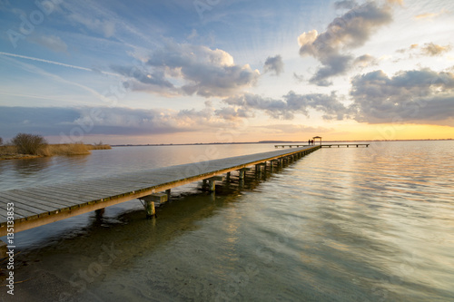 Fototapeta Naklejka Na Ścianę i Meble -  wooden pier overlooking the lake, the beautiful evening sky