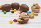 Chocolate Easter Eggs and Cupcake Over Wooden Background