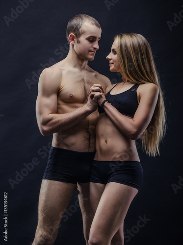 Young sporty couple in the dark