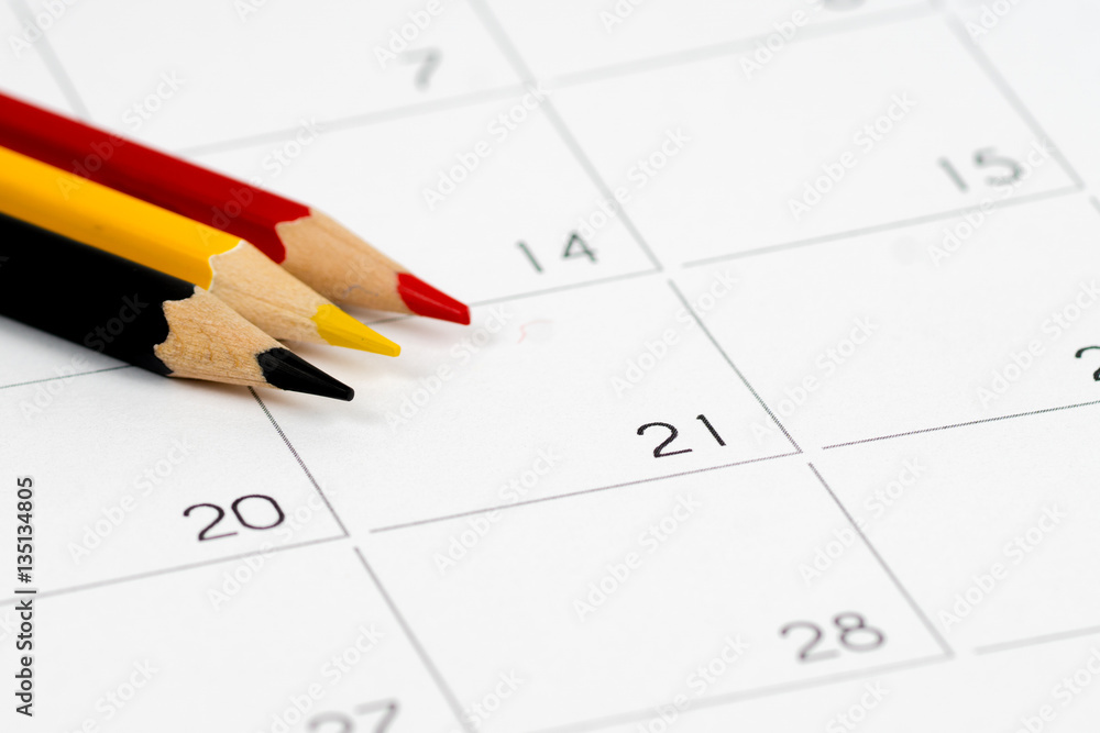 black yellow red pencils on empty calendar grid black yellow red pencils on empty calendar grid
