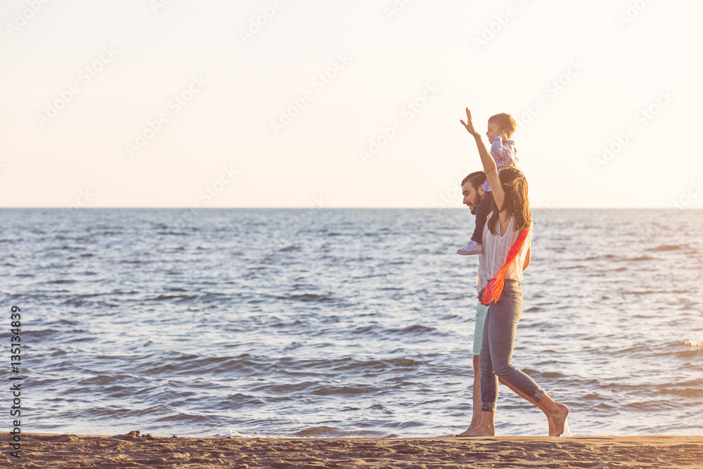 happy young family have fun on beach run and jump at sunset happy young family have fun on beach run and jump at sunset