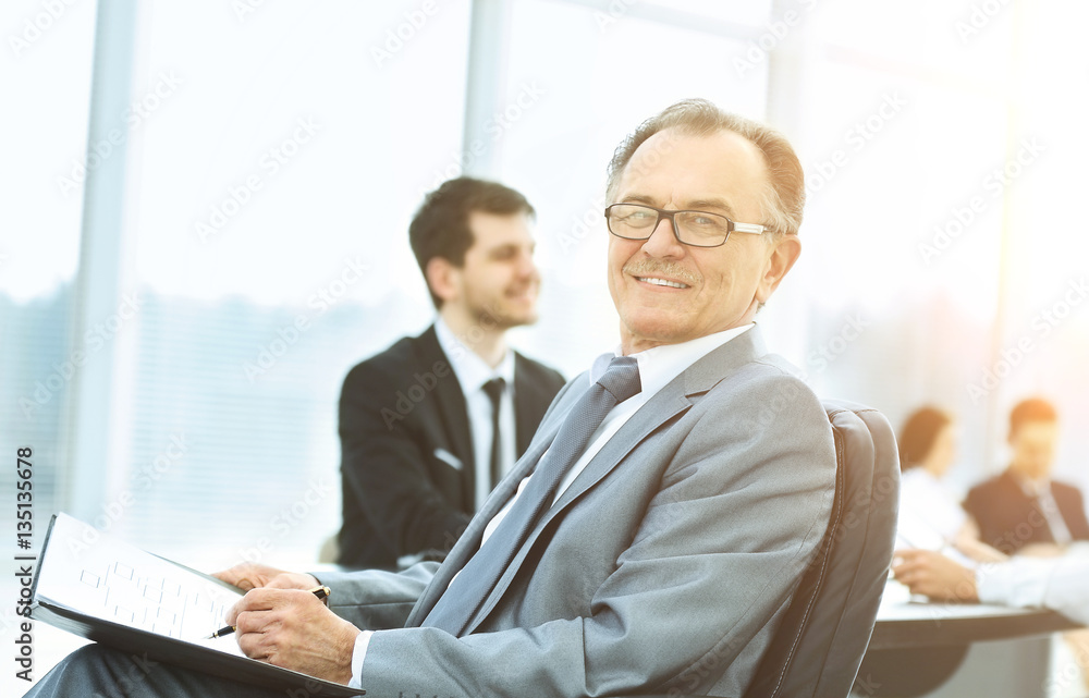 Portrait of a successful businessman in the office on the background working business team Portrait of a successful businessman in the office on the background working business team