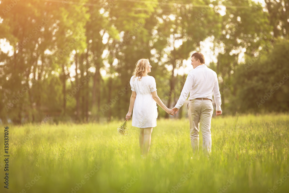 Happy couple - pregnant woman and her husband go on a picnic the grass. Happy couple - pregnant woman and her husband go on a picnic the grass.