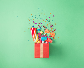 Gift box with party confetti, balloons, streamers, noisemakers,