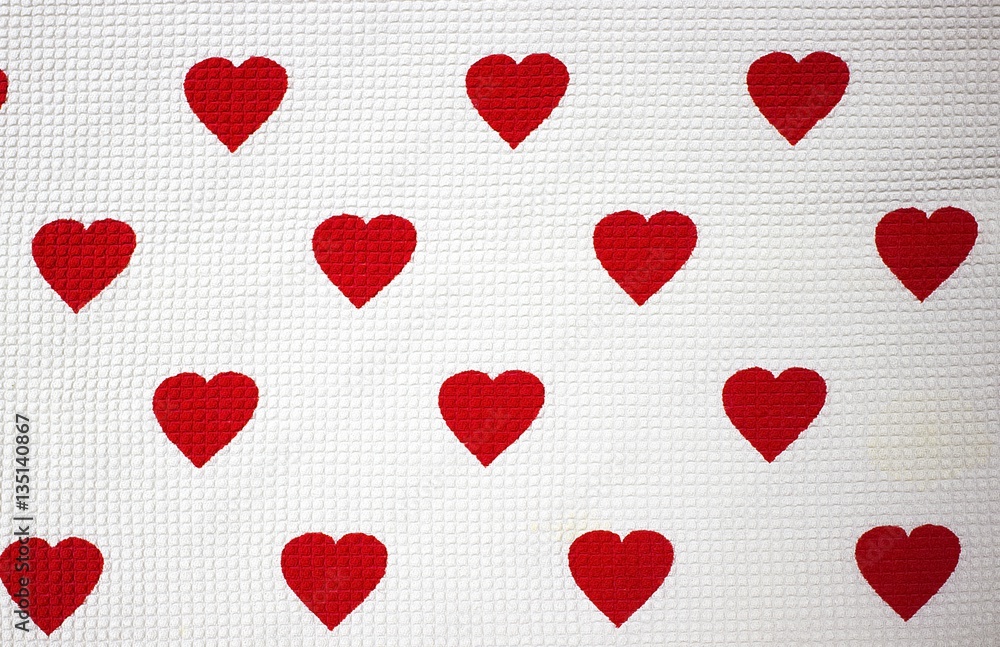 A white fabric background with red  hearts