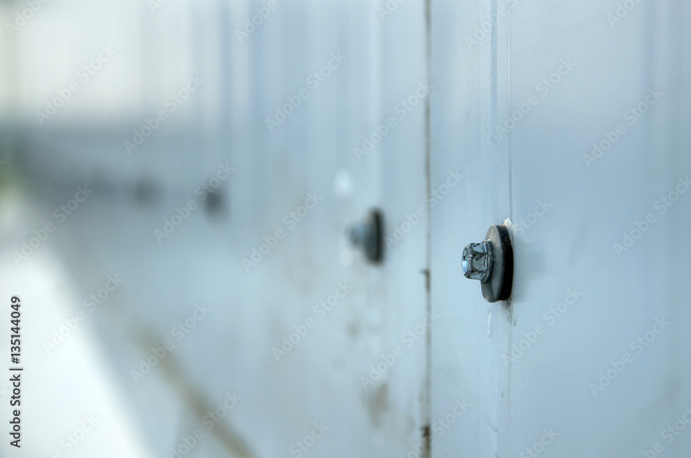 Facade lined with metal panels. Fixing element closeup selective focus. Facade lined with metal panels. Fixing element closeup selective focus.