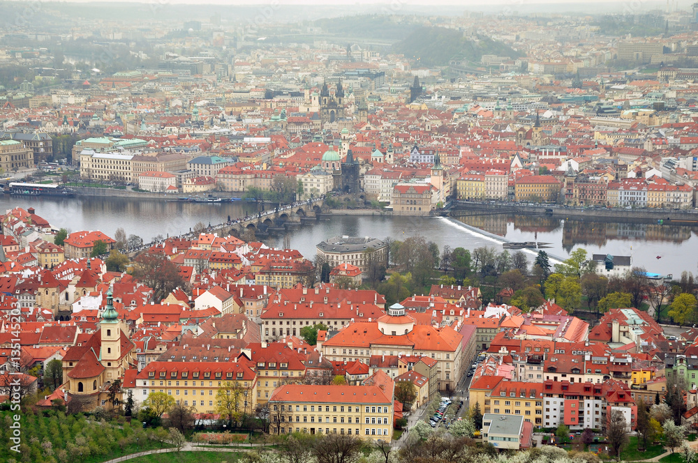 Aerial panoramic view of the historic center of Prague, Czech Republic. River Vltava, red tiled roofs and towers in perspective.