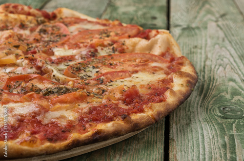 Pizza with mozzarella on wooden background. Close-up