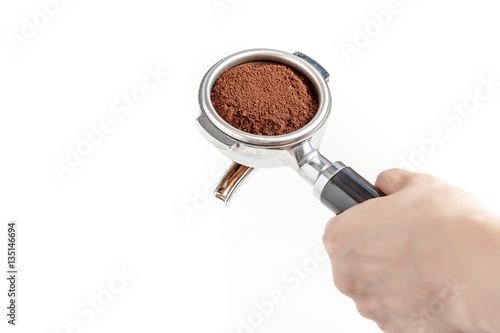 Barista hold the portafilter with coffee ground, prepare to tamp and brew espresso shot