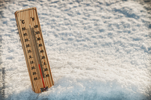 Wooden Thermometer in the snow with freezing temperatures. vignetting as an artistic effect