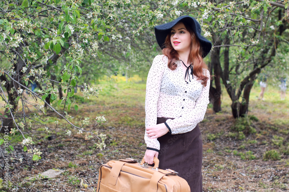 Obraz premium woman in retro dress outdoor suitcase park