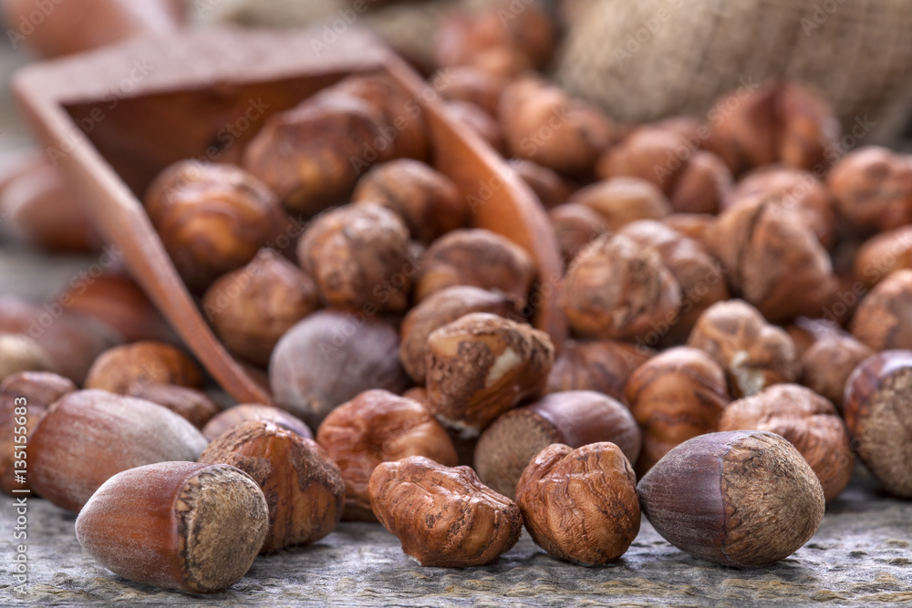 Hazelnuts and a spoon on an old wooden table