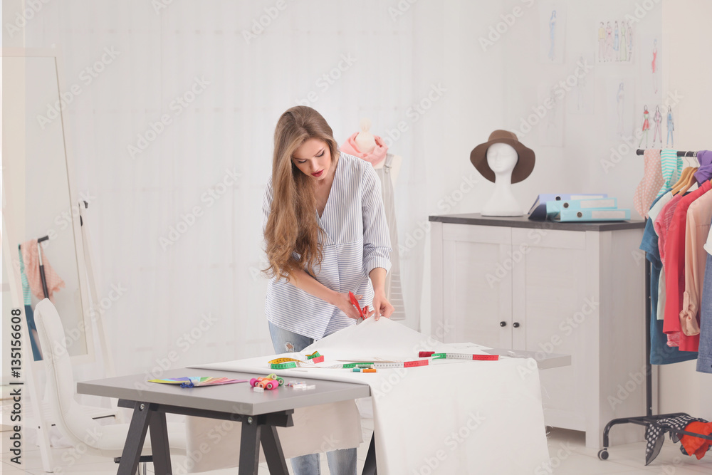 Beautiful young fashion designer working in office Beautiful young fashion designer working in office